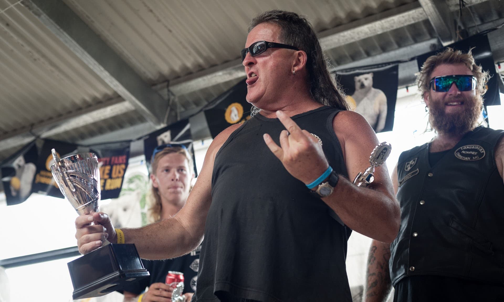 Rock dog with a sick mullet holding a trophy for winning "Greatest Mullet of All"