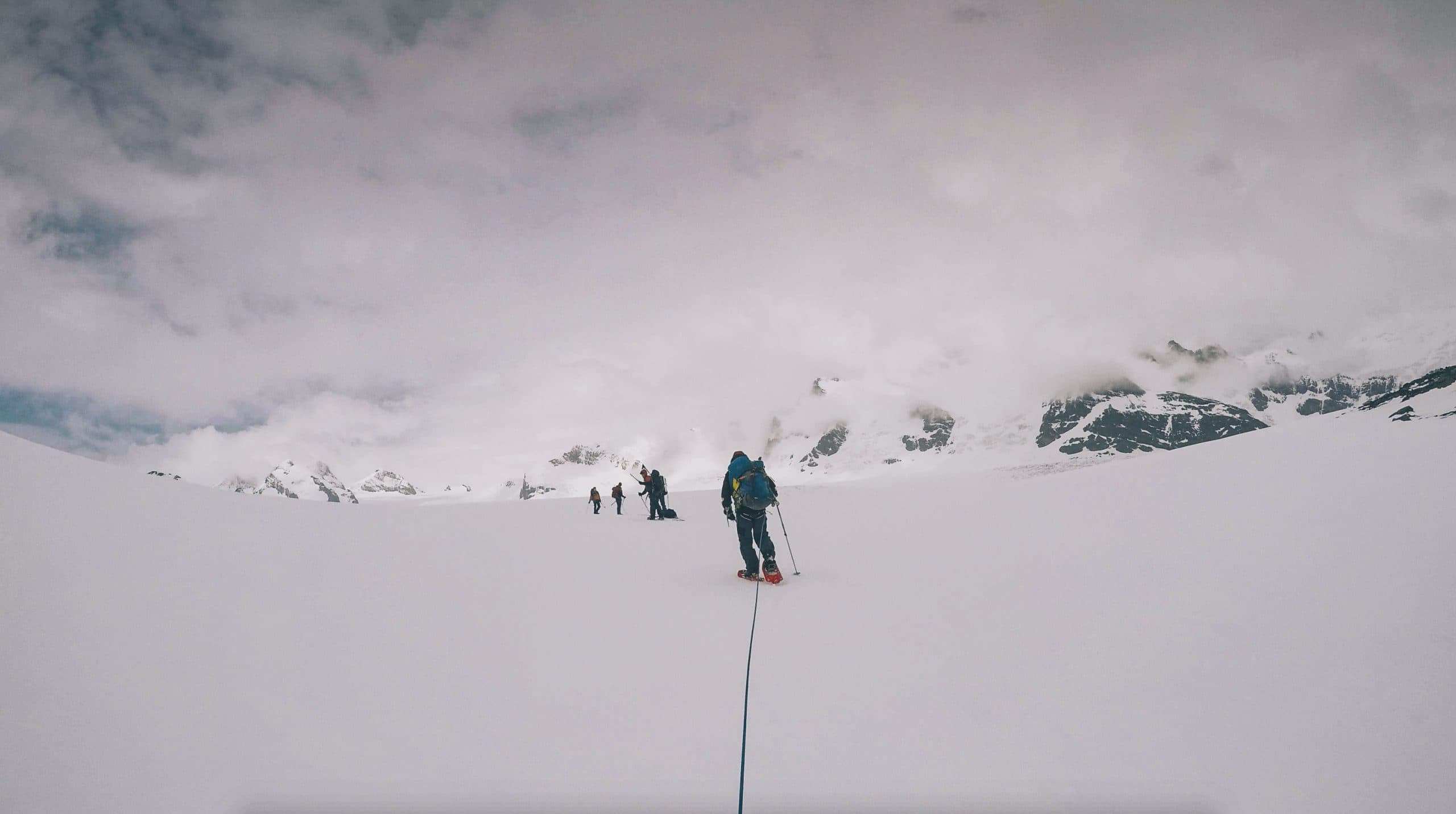 Shackleton Gap. Antarctic. 3 figures ahead trekking through the ice. POV attached by a rope behind 3 figures trekking through the ice. Point of view shot trekking through the ice. Antarctic expedition.
