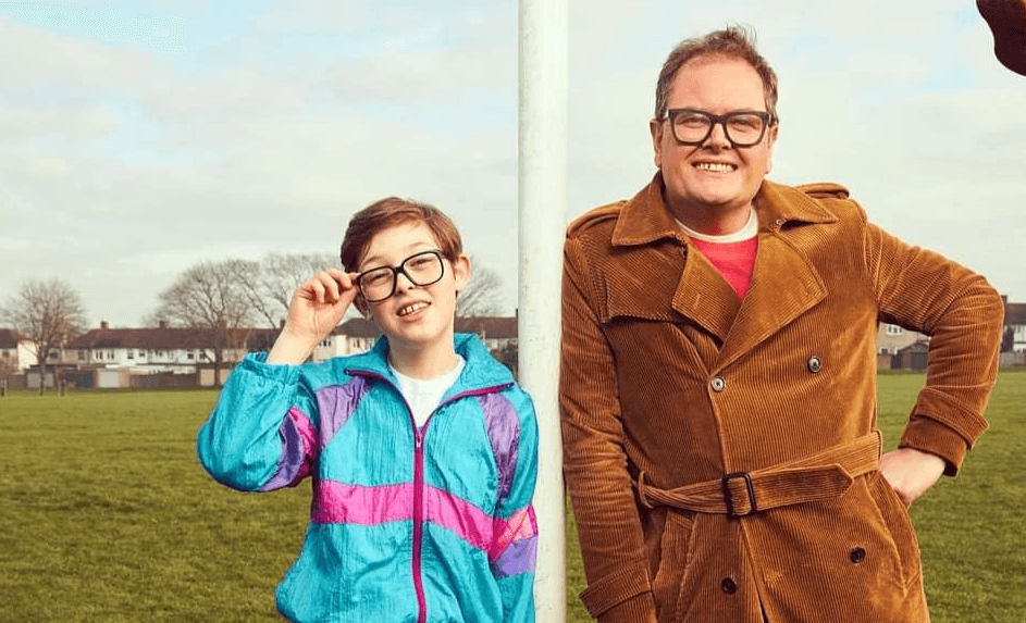 Poster for the TV show Changing Ends, showing Alan Carr and the actor playing young Alan, Oliver Savell. They are outdoors standing on a football field leaning on a football goalpost.